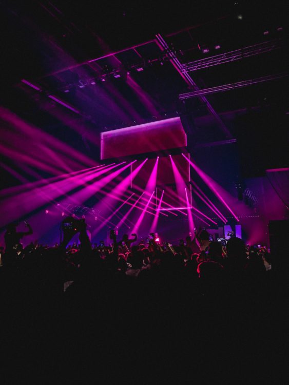 people performing on stage near partying people