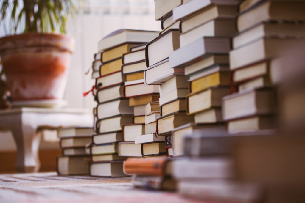 Piles of books stacked on a carpet
