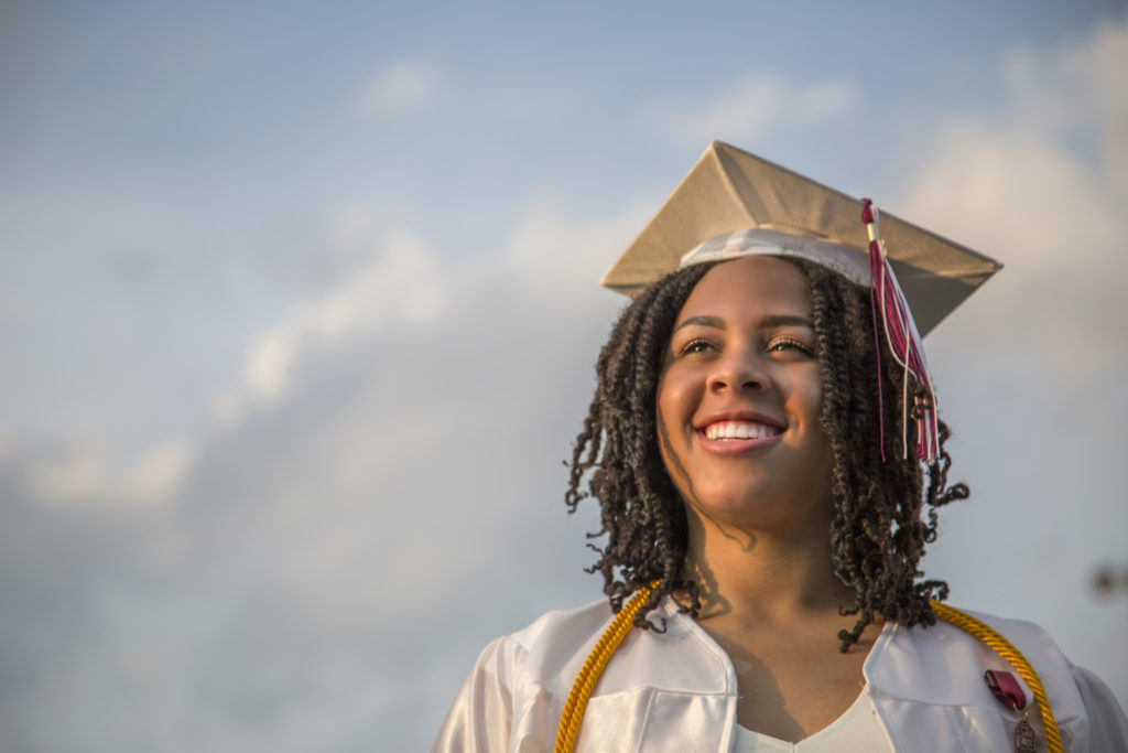 Portrait of happy teenage girl at graduation ceremony