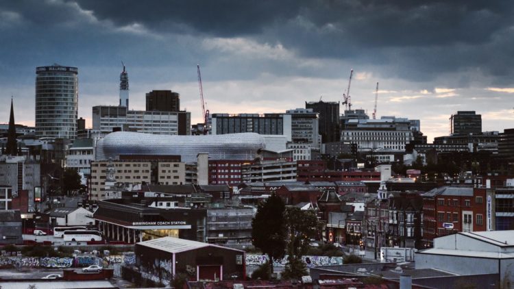 concrete building and houses under gray sky