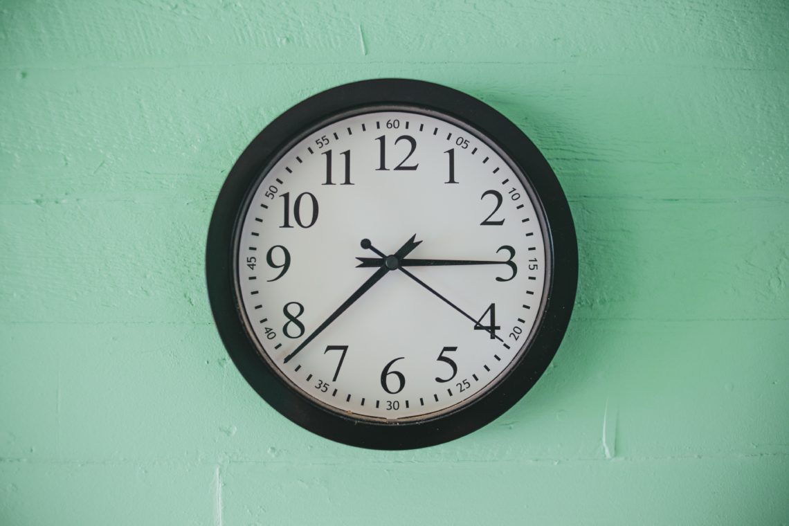 black and white analog wall clock at 10 00