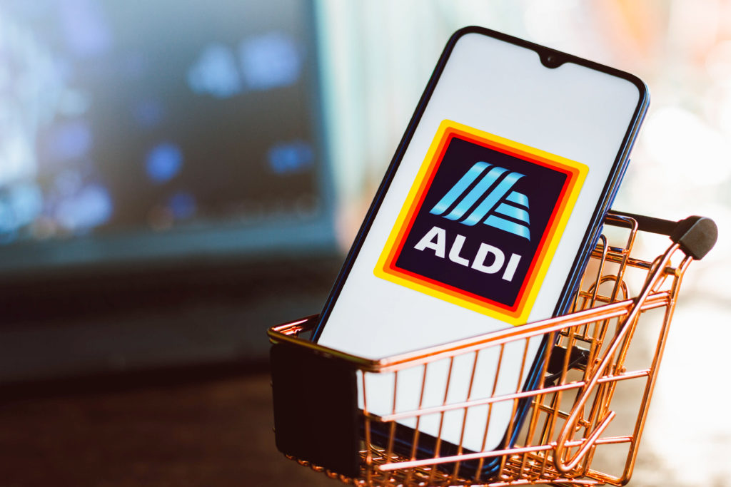 In this photo illustration, an Aldi logo seen displayed on a