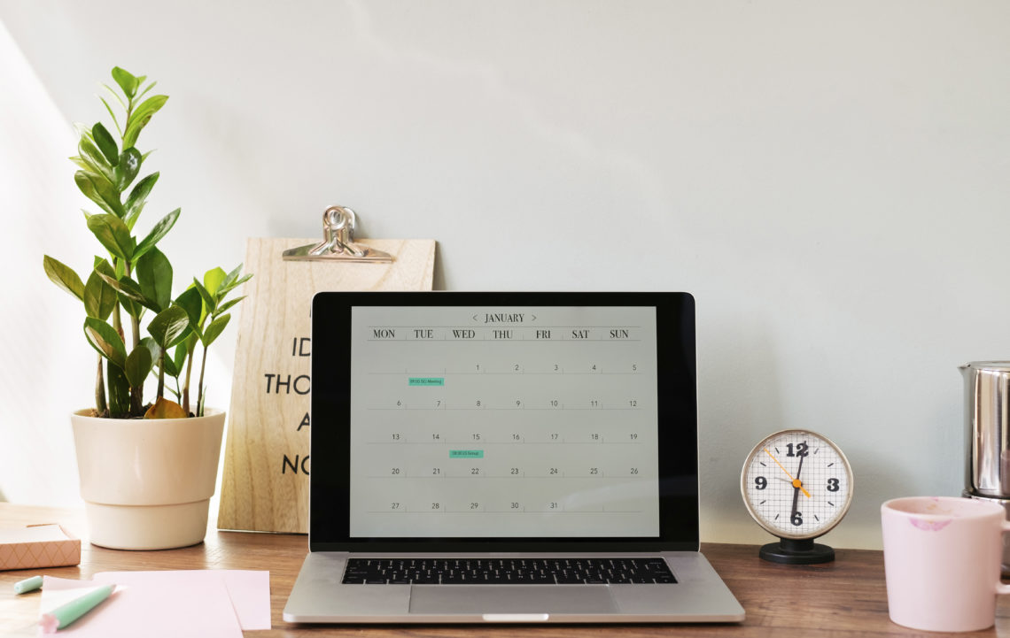 Opened laptop with a calendar on desk at home office