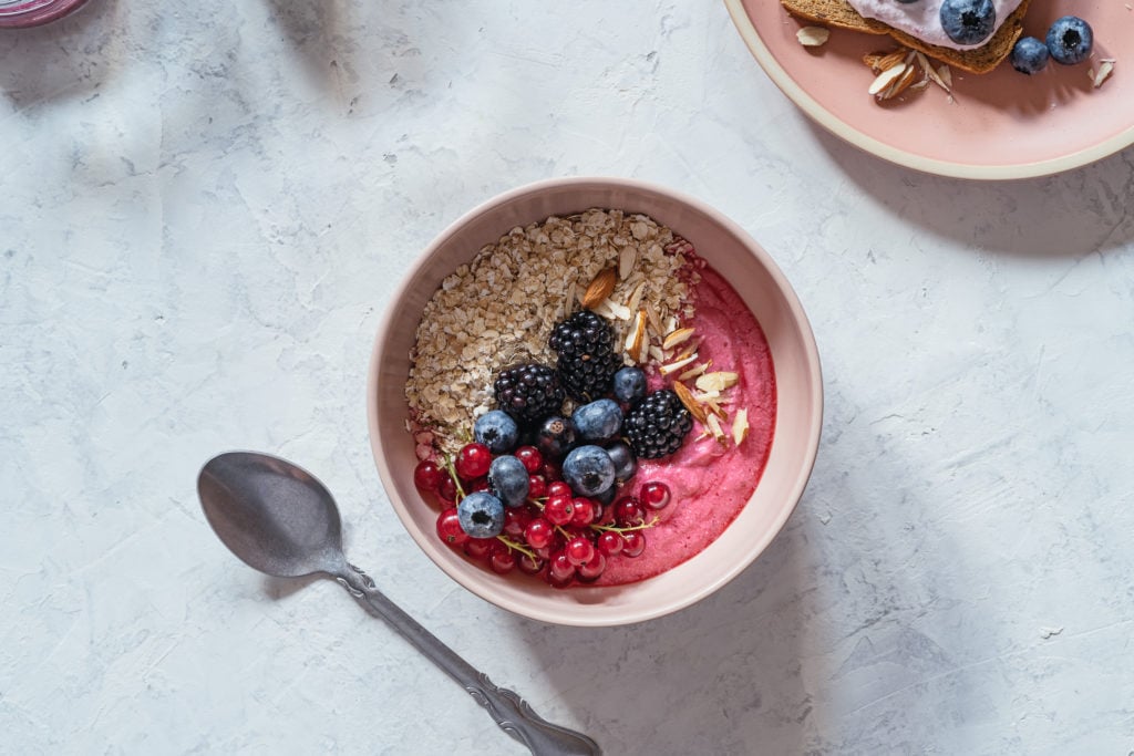 Breakfast, smoothie bowl with fresh berries, rolled oats, almonds