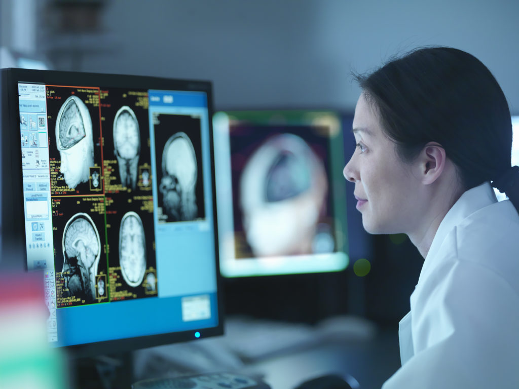 Scientist looking at 3D rendered graphic scans from Magnetic Resonance Imaging (MRI) scanner, close up