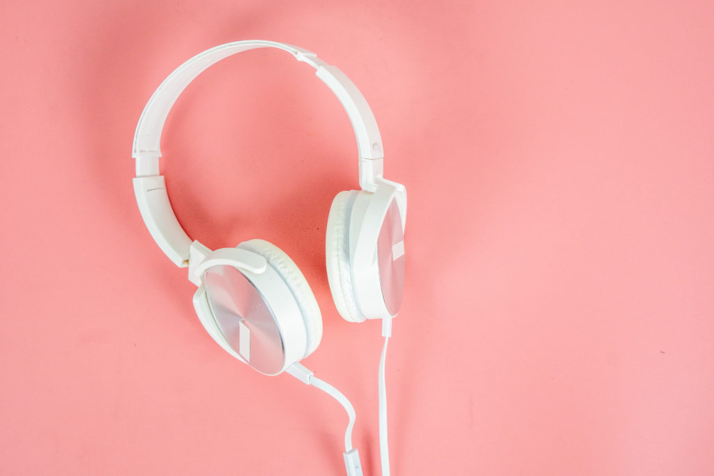 White earphones on pink background.