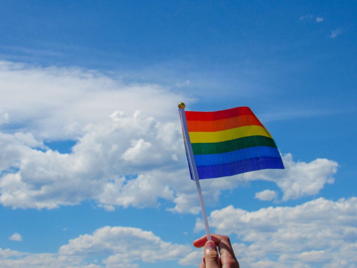 person holding flag of america under white clouds and blue sky during daytime