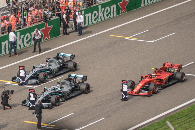 three F1 racing in road during daytime