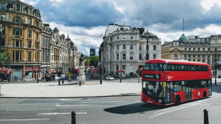 red and black bus on road near building during daytime