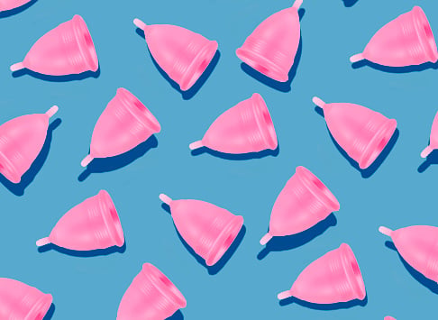Eco-friendly and reusable pink menstrual cup pattern on blue background