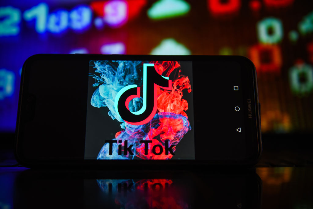 In this photo illustration a TikTok logo seen displayed on a