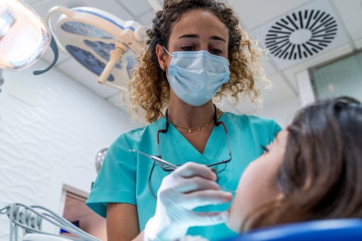 Low angle view of dentist woman examining little girl at dentist's office