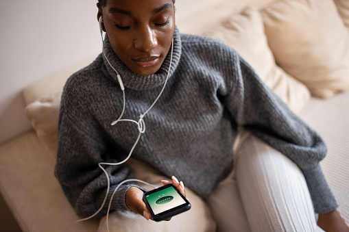 Woman using nature's sound on phone app to meditate