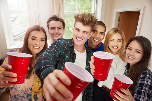 young adult toasting camera