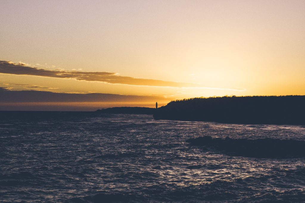 silhouette of cliff and body of water