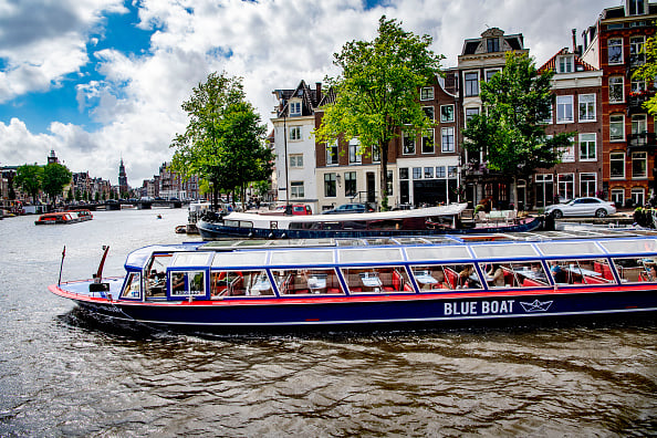 Tourists take a boat tour through the canals of Amsterdam.