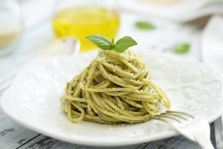 Pesto spaghetti on white wooden table