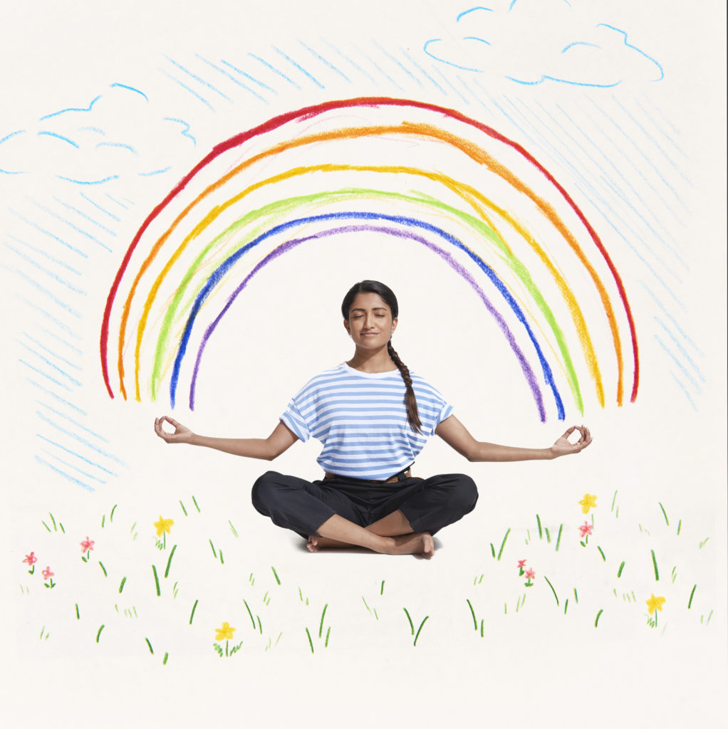woman meditating with rainbow