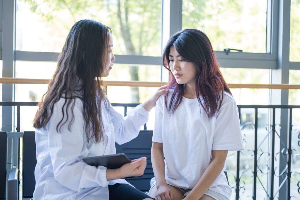 A female psychologist is comforting a girl