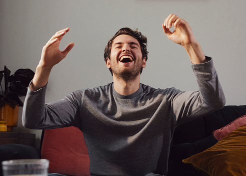 Young man cheering with his arms raised.