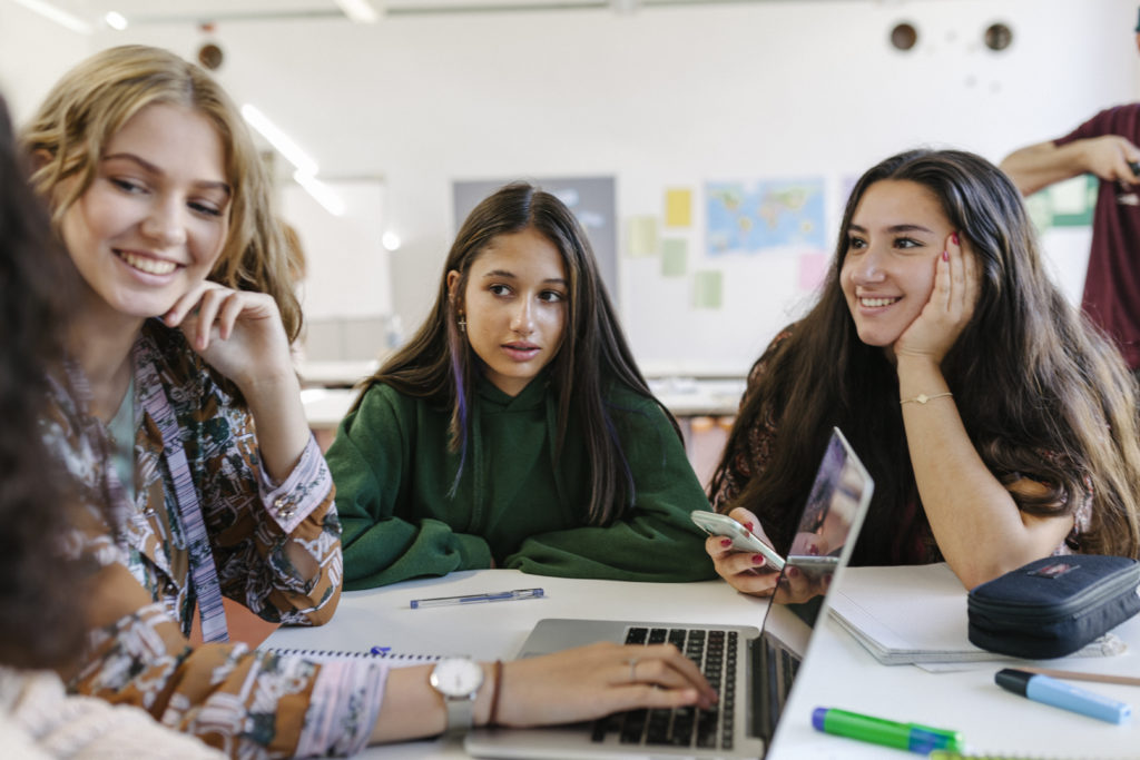 Three Friends Working Together On Task During Class