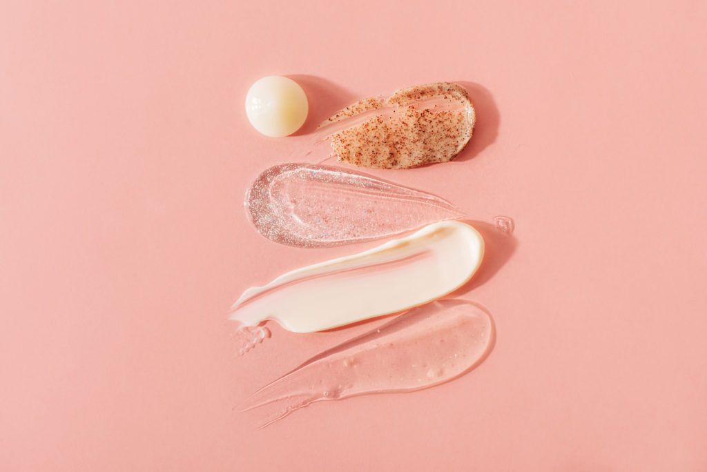 White cream for the face on pink background. Body care and beauty. Skin care product