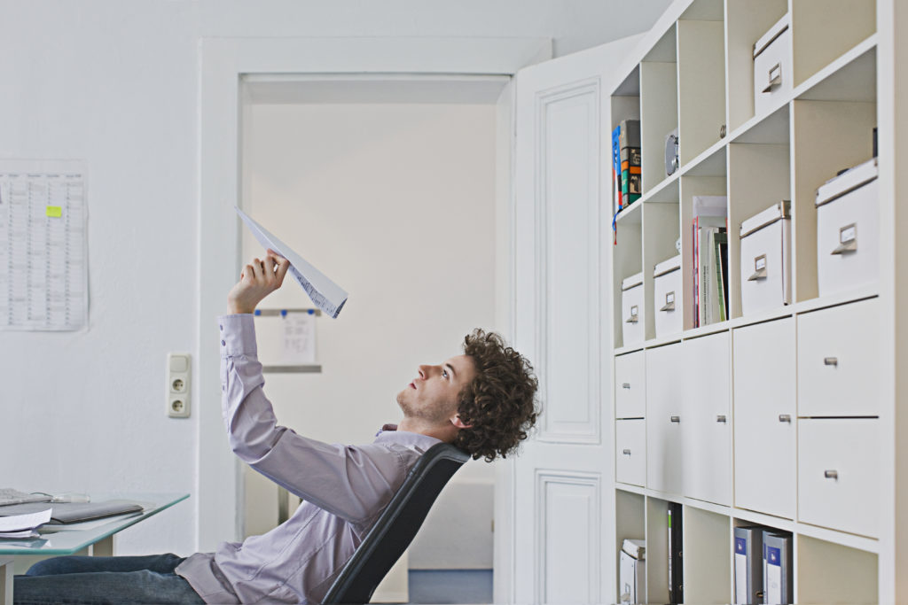 Businessman holding paper airplane