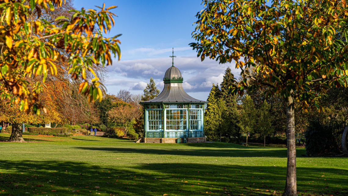 white and brown concrete building near green grass field under blue sky during daytime