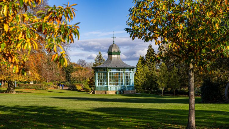 white and brown concrete building near green grass field under blue sky during daytime