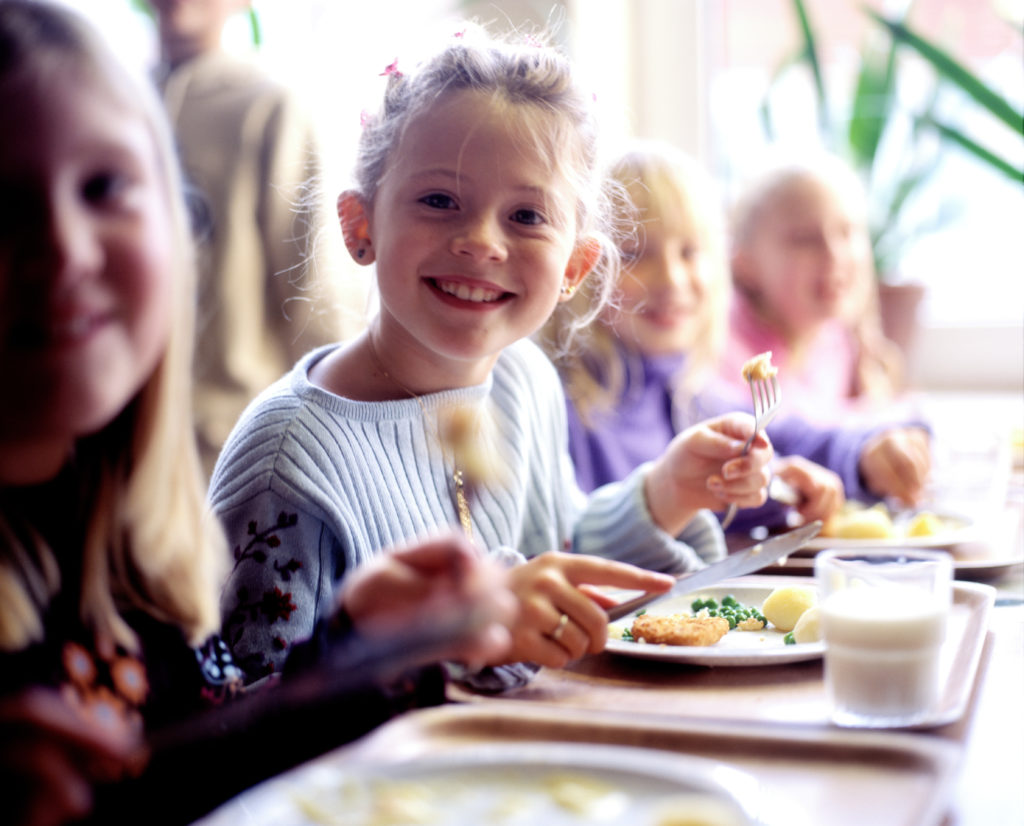 Children (6-8) eating school dinner, portrait