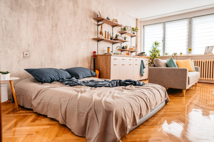 Messy bed in studio apartment in the morning.