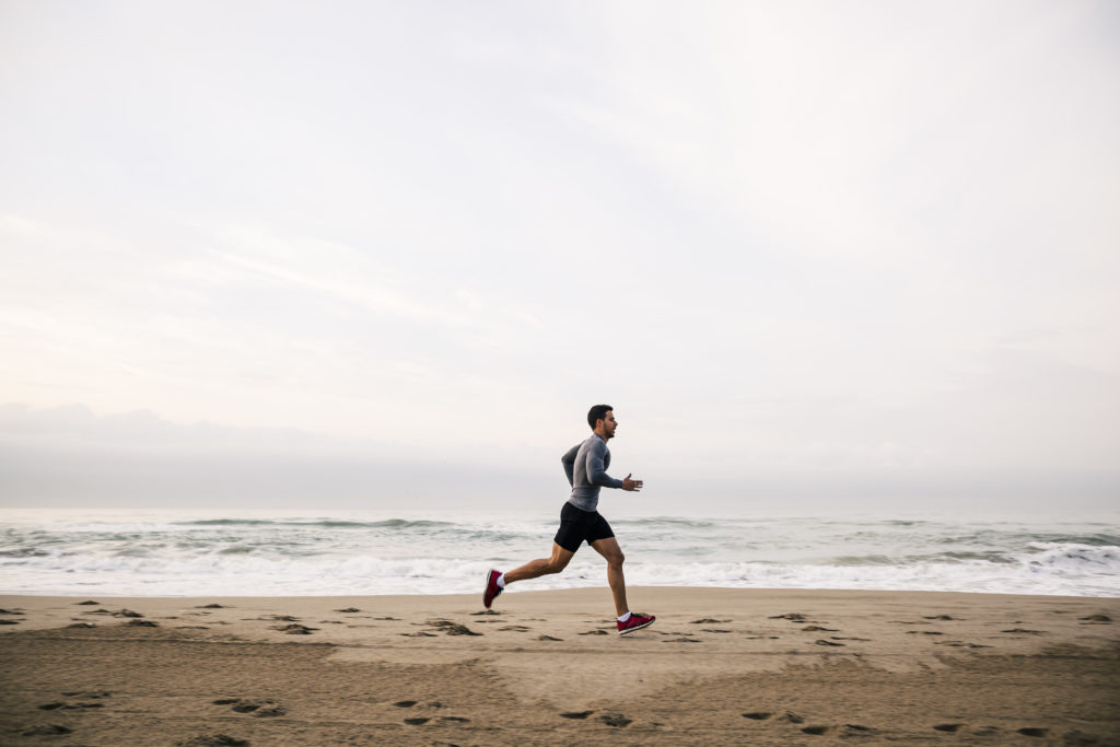 Young man running on the beach