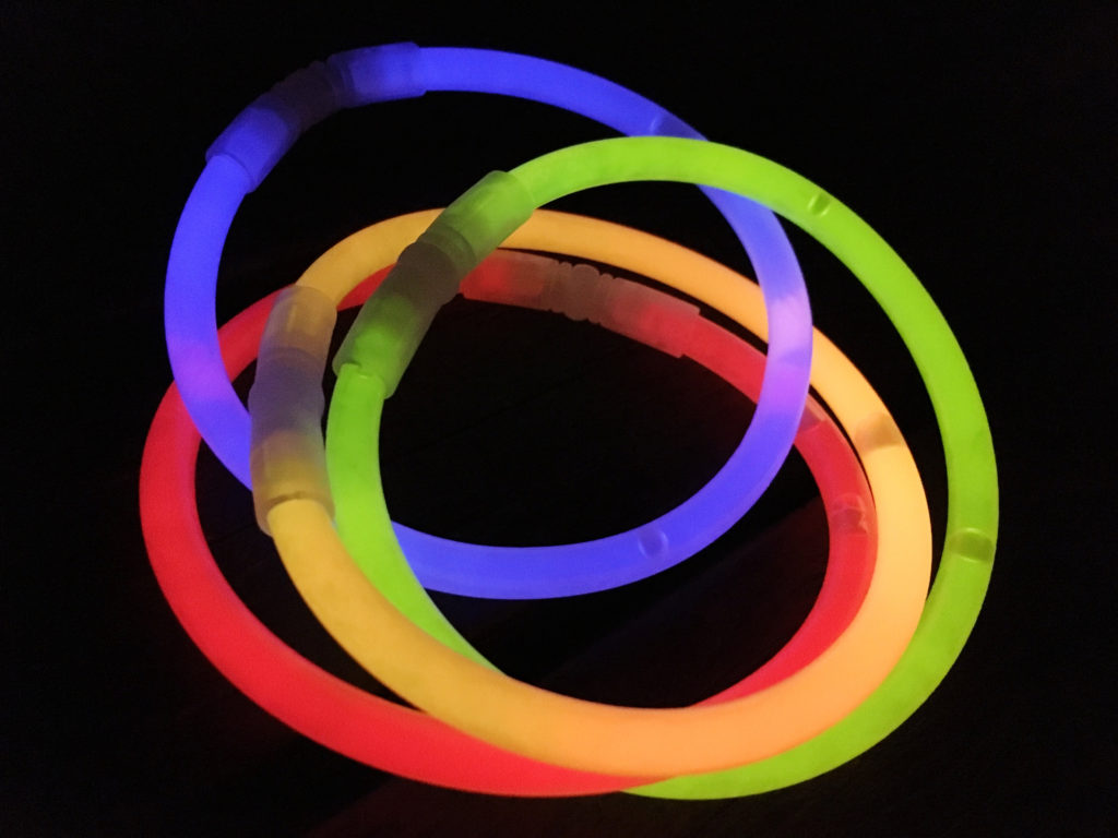 Close-Up Of Colorful Glow Sticks Over Black Background
