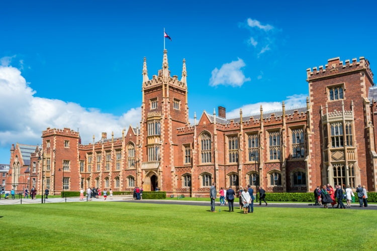 People walk at the Queen's University Belfast campus, Northern Ireland, United Kingdom on a sunny day.