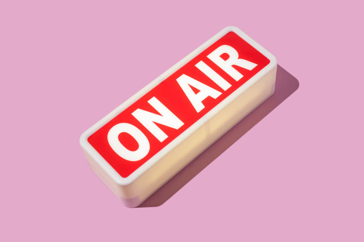 Radio and sound recording warning light that reads: 'ON AIR' with hard shadow on pink background. Podcast, radio, broadcast, radio show, entertainm...