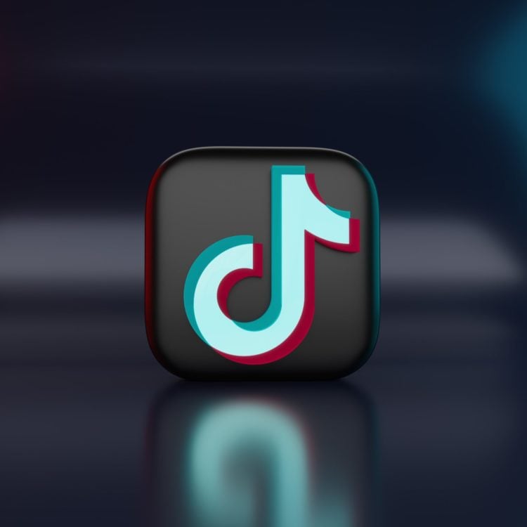 tiktok logo on 3d black block against reflective navy background