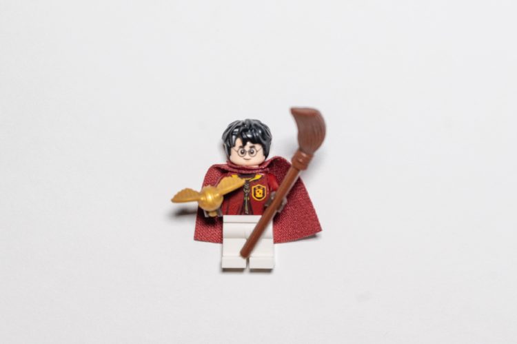 boy in yellow and red shirt holding brown wooden stick figurine