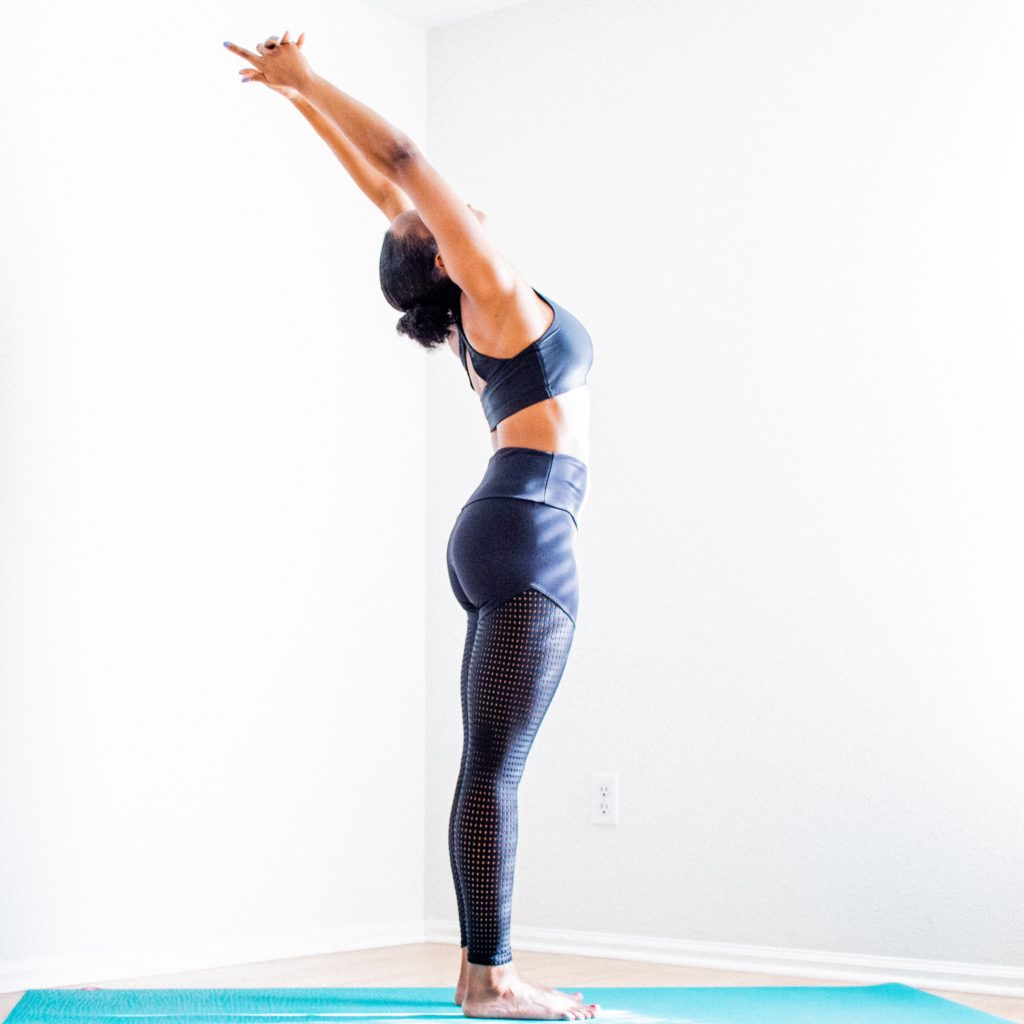 woman stretching wearing black bra and pants