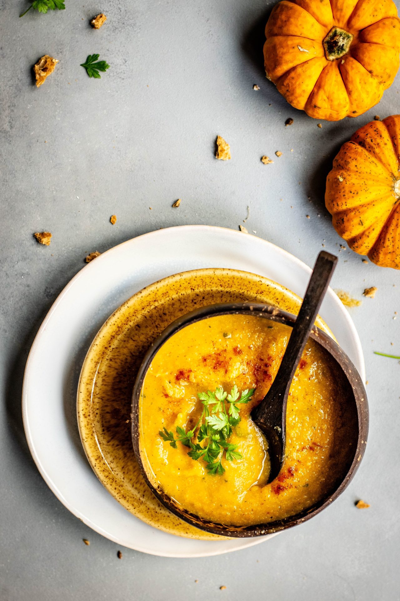 bowl of soup near two pumpkins