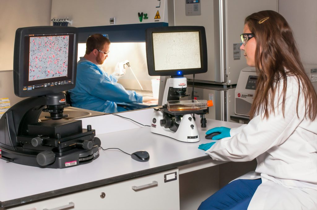 medical student sat at desk with microscope