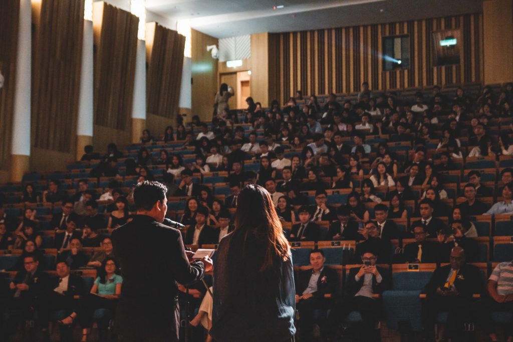 university lecturer delivering lesson to full lecture hall