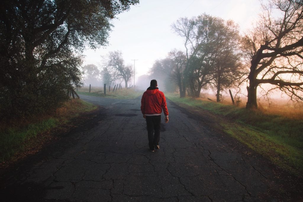 man walking on road at daytime