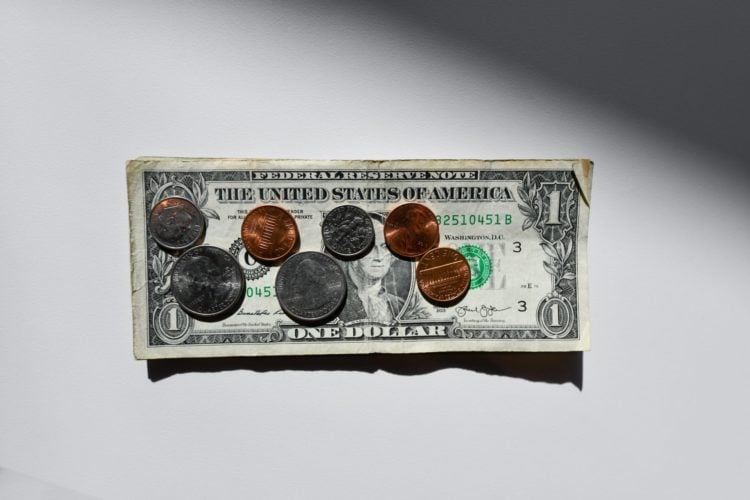 dollar note with coins on top on white background