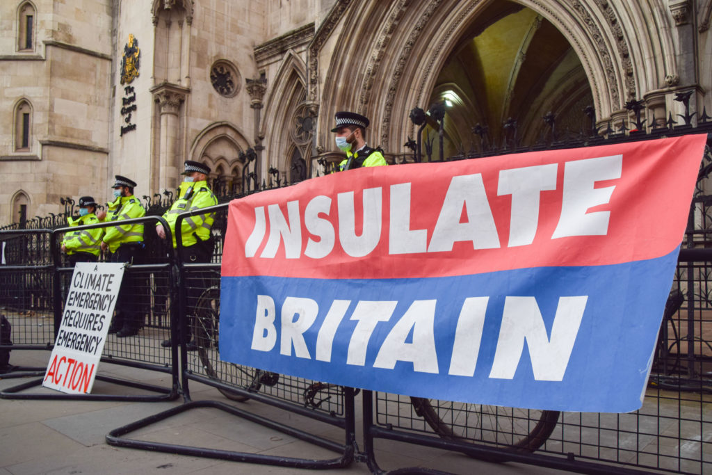 Police officers stands next to an Insulate Britain banner