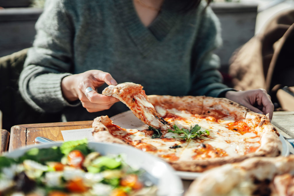 Close up shot of woman enjoying Italian food at outdoor restaurant