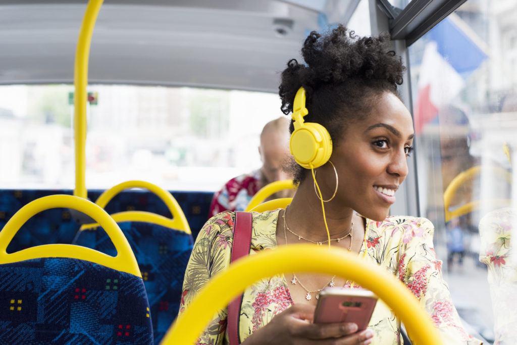 Portrait of woman relaxing on a bus wearing headphones