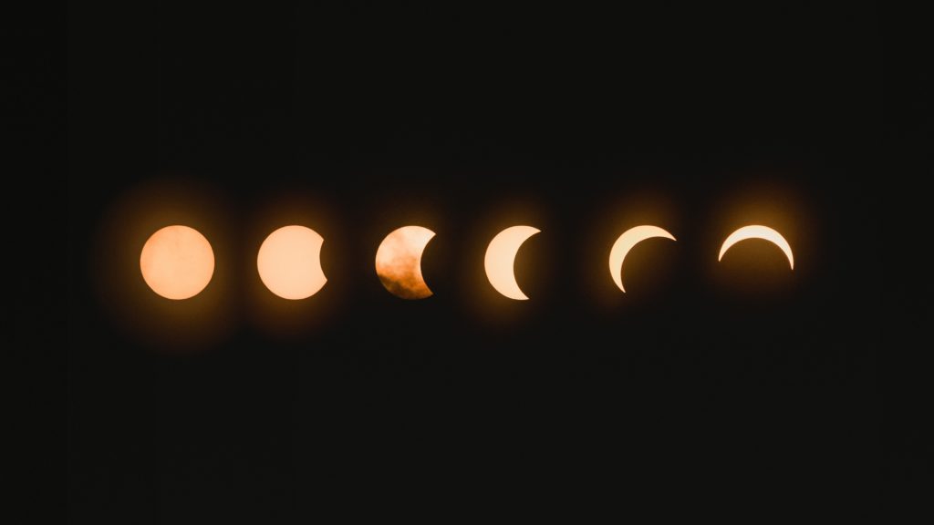 phases of a lunar eclipse next to each other on black background