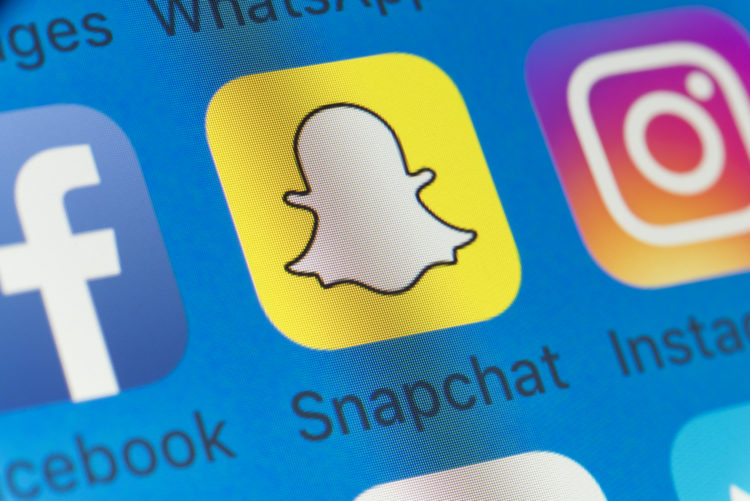 London, UK - August 01, 2018: The buttons of Snapchat, Facebook, Instagram and WhatsApp on the screen of an iPhone.