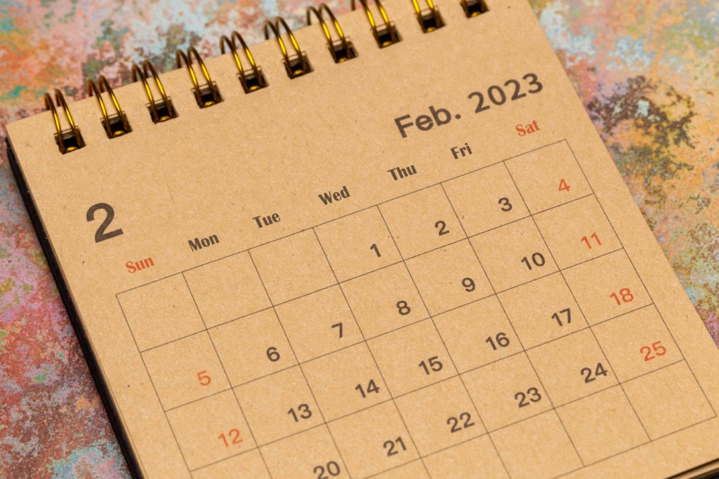 month of february 2023 on a desk calender with a brown paper background