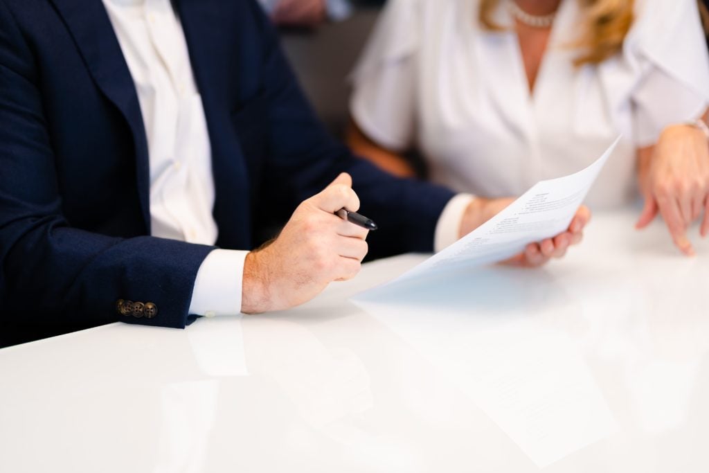two people sitting at table looking at document